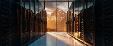 Modern data center with rows of black server racks framing a panoramic view of the Canadian Rocky Mountains at golden hour