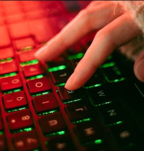 Close-up of a backlit keyboard with red and green lighting, representing urgent security patching