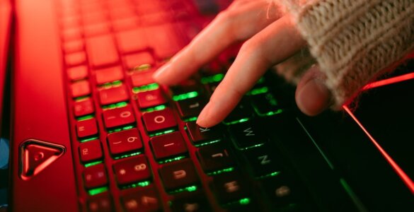Close-up of a backlit keyboard with red and green lighting, representing urgent security patching