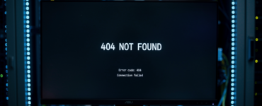 Monitor in server room displaying 404 Not Found error with blue LED server rack lighting