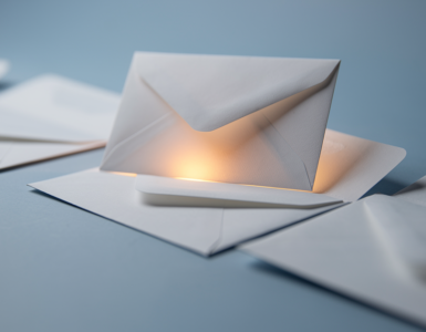 White envelopes on a soft blue surface, one lifted and highlighted