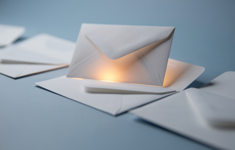 White envelopes on a soft blue surface, one lifted and highlighted