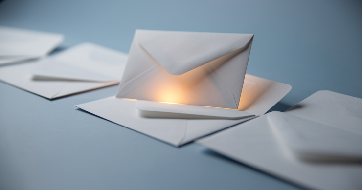White envelopes on a soft blue surface, one lifted and highlighted