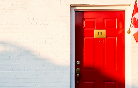 Bright red front door with brass number plate and a small Canadian flag