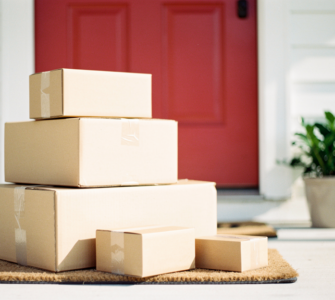 Unopened delivery parcels stacked on a front doorstep